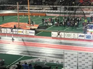 A track and field athlete races against other athletes on a track