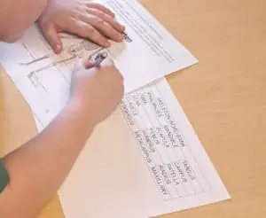 A student labels parts of the human skeleton using words from a word bank
